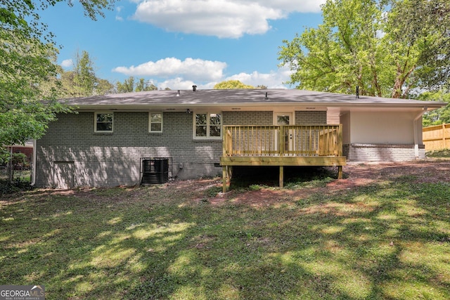 back of property featuring a wooden deck, a yard, brick siding, and central AC