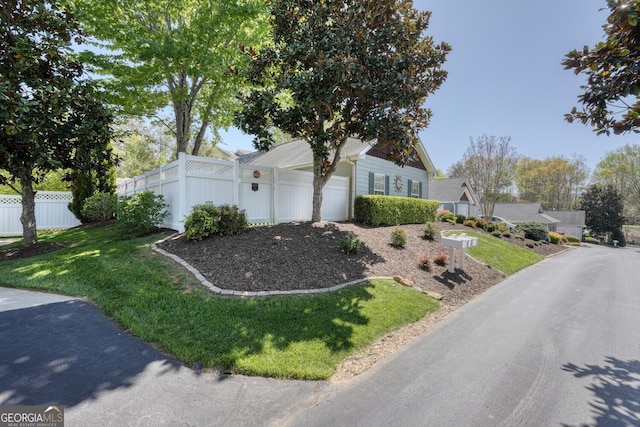 view of front of property with a garage, a front lawn, and fence