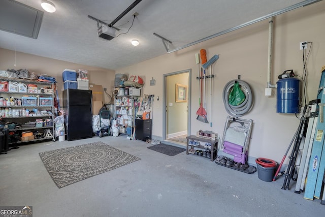 garage with freestanding refrigerator and a garage door opener