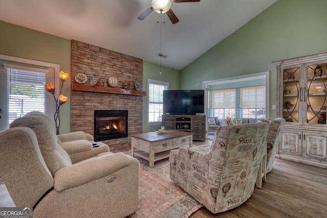 living area featuring a fireplace, a healthy amount of sunlight, and a ceiling fan