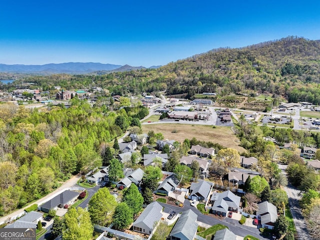 birds eye view of property featuring a forest view, a mountain view, and a residential view