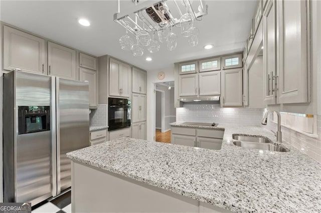 4044 Ashentree Dr, Brookhaven, GA 30341 - kitchen featuring a peninsula, a sink, stainless steel fridge with ice dispenser, under cabinet range hood, and black oven