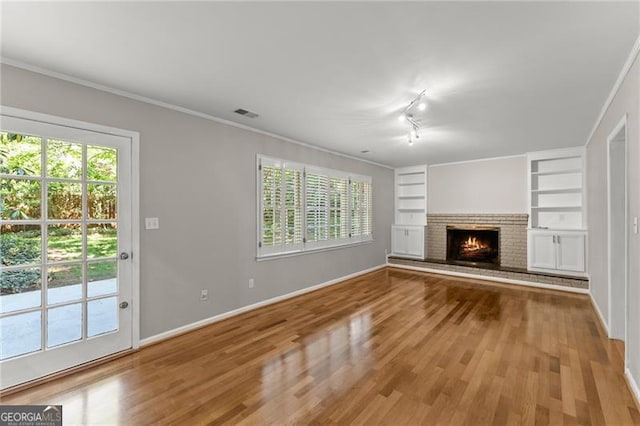 4044 Ashentree Dr, Brookhaven, GA 30341 - unfurnished living room with wood finished floors, visible vents, ornamental molding, baseboards, and built in shelves