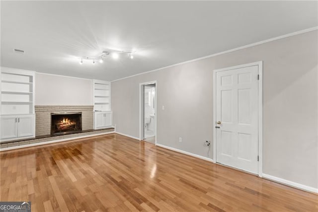 4044 Ashentree Dr, Brookhaven, GA 30341 - unfurnished living room featuring light wood finished floors, crown molding, baseboards, a brick fireplace, and built in features