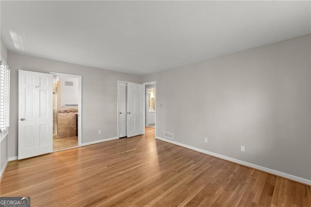 4044 Ashentree Dr, Brookhaven, GA 30341 - unfurnished bedroom featuring ensuite bath, light wood-type flooring, visible vents, and baseboards