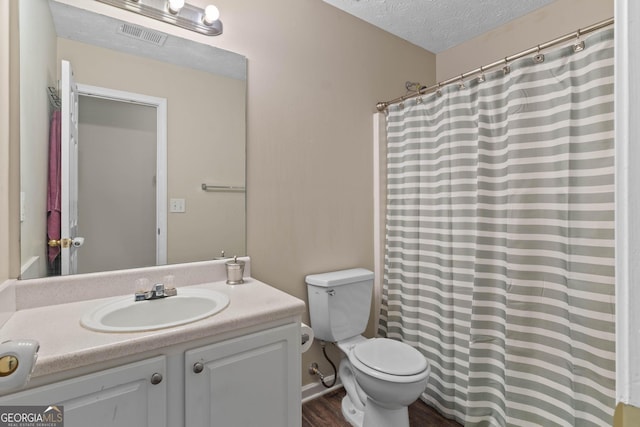 1012 Miss Amber Way, Locust Grove, GA 30248 - bathroom featuring toilet, vanity, a textured ceiling, wood finished floors, and a shower with shower curtain