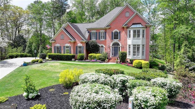 view of front of home featuring a front lawn and brick siding