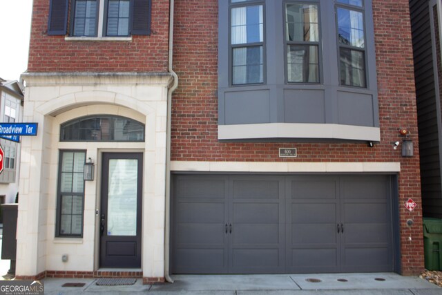 600 Broadview Ter NE, Atlanta, GA 30324 - property entrance with brick siding, an attached garage, stone siding, and driveway