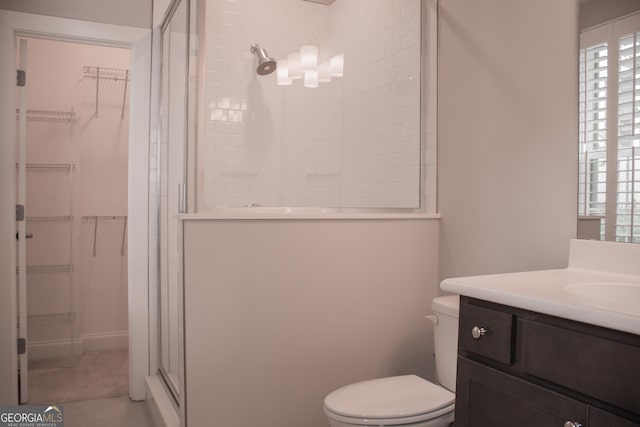600 Broadview Ter NE, Atlanta, GA 30324 - bathroom with toilet, vanity, a spacious closet, and a stall shower