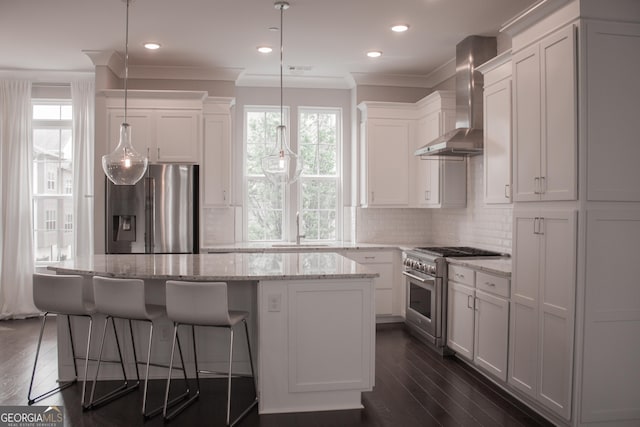 600 Broadview Ter NE, Atlanta, GA 30324 - kitchen featuring wall chimney range hood, a healthy amount of sunlight, stainless steel appliances, and a kitchen island