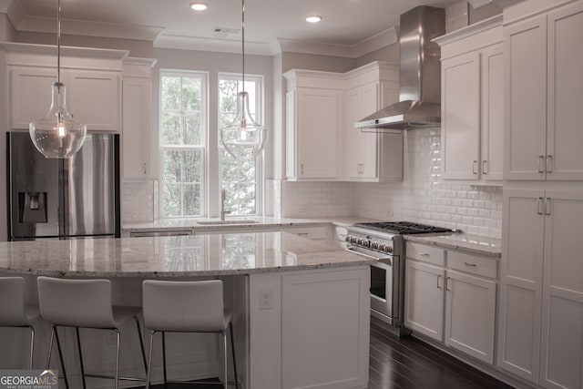 600 Broadview Ter NE, Atlanta, GA 30324 - kitchen featuring white cabinets, a kitchen island, wall chimney exhaust hood, and stainless steel appliances