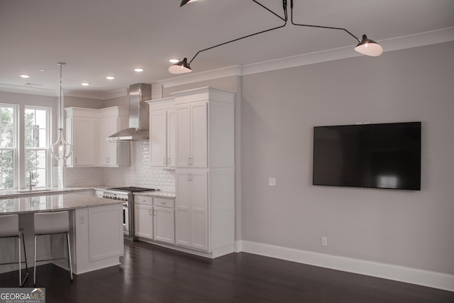 600 Broadview Ter NE, Atlanta, GA 30324 - kitchen featuring white cabinets, wall chimney range hood, light stone countertops, tasteful backsplash, and stainless steel range