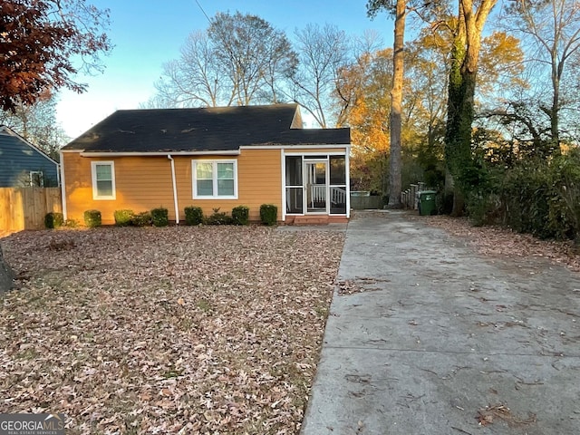 back of house with concrete driveway and fence
