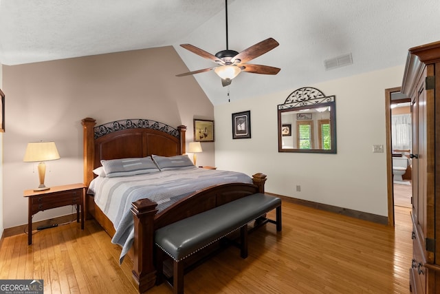 bedroom featuring lofted ceiling, visible vents, baseboards, light wood-style flooring, and ceiling fan