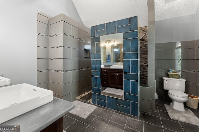 full bath with lofted ceiling, tile patterned flooring, toilet, vanity, and tile walls