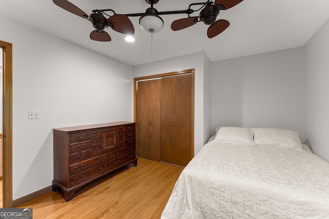 bedroom with a closet, light wood finished floors, and a ceiling fan