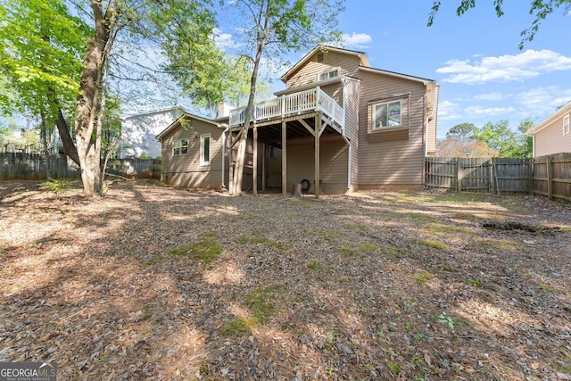 back of house with a fenced backyard and a deck