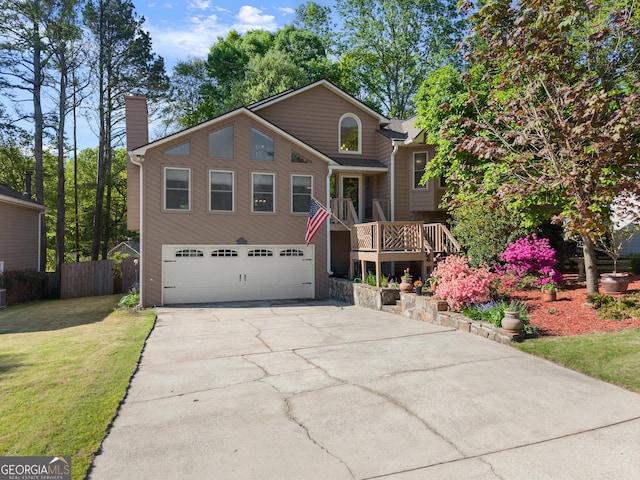 view of front of property featuring a chimney, fence, a front lawn, concrete driveway, and a garage
