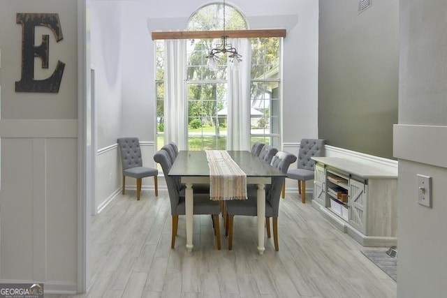 1163 Bristol Hammock Cir, Kingsland, GA 31548 - dining area featuring a chandelier, light wood-style floors, and a wainscoted wall