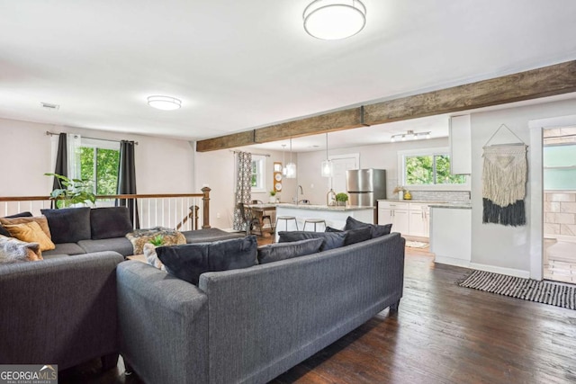 living area with dark wood-style flooring, a healthy amount of sunlight, and visible vents