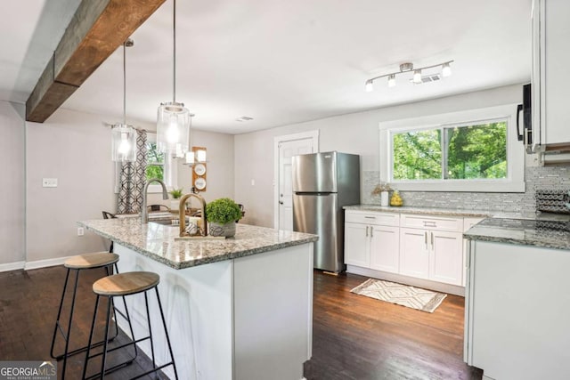 kitchen featuring dark wood finished floors, tasteful backsplash, white cabinetry, and freestanding refrigerator