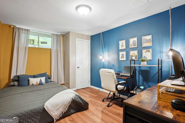 bedroom featuring visible vents, baseboards, and wood finished floors