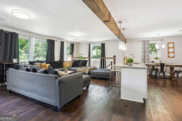 living room with dark wood-type flooring and beamed ceiling