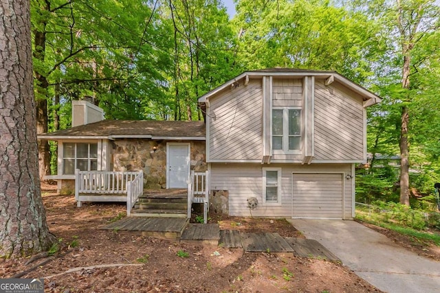 5307 Jay Way NW, Lilburn, GA 30047 - split level home with a chimney, driveway, stone siding, an attached garage, and a wooden deck