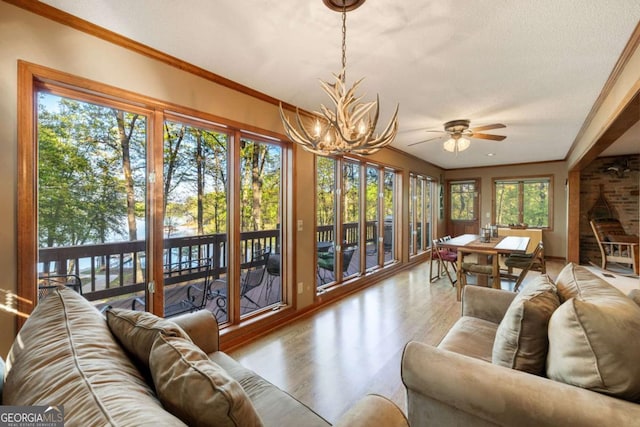 736 Cedar Ridge Rd, Hartwell, GA 30643 - sunroom with ornamental molding, a chandelier, wood finished floors, and a water view
