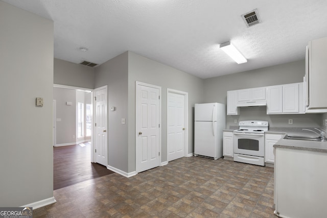 kitchen featuring visible vents, baseboards, white appliances, and a sink