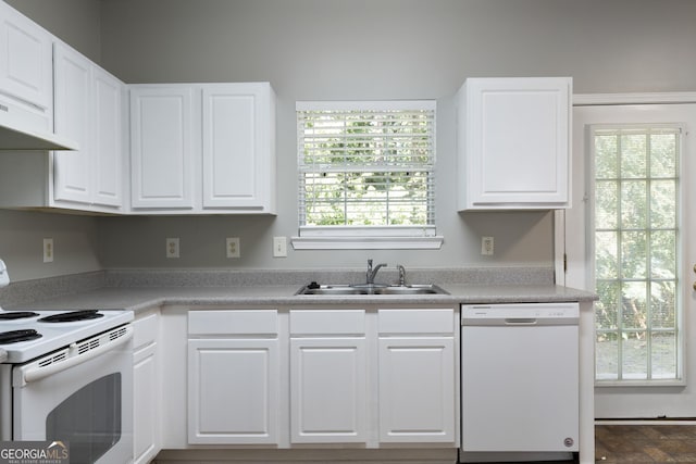 kitchen with a sink, white cabinetry, white appliances, light countertops, and under cabinet range hood