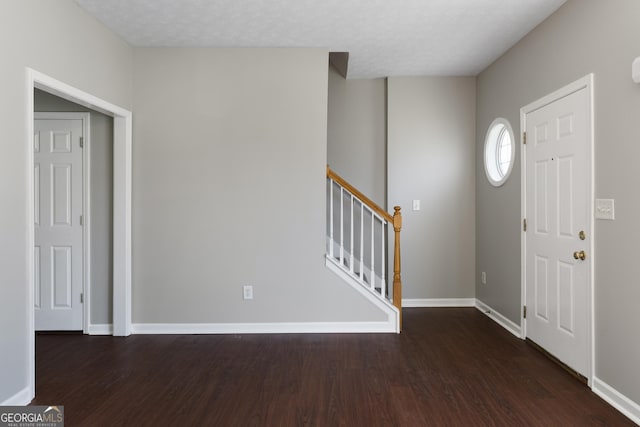 entrance foyer featuring baseboards, wood finished floors, and stairs