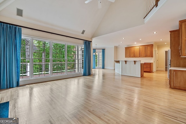 unfurnished living room featuring light wood finished floors, high vaulted ceiling, ceiling fan, and recessed lighting