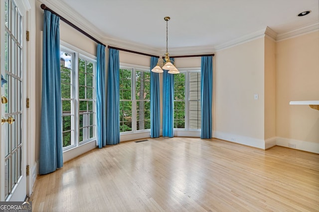 unfurnished room featuring wood finished floors, baseboards, and ornamental molding