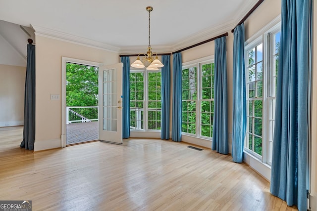 doorway to outside featuring crown molding, wood finished floors, a chandelier, and baseboards