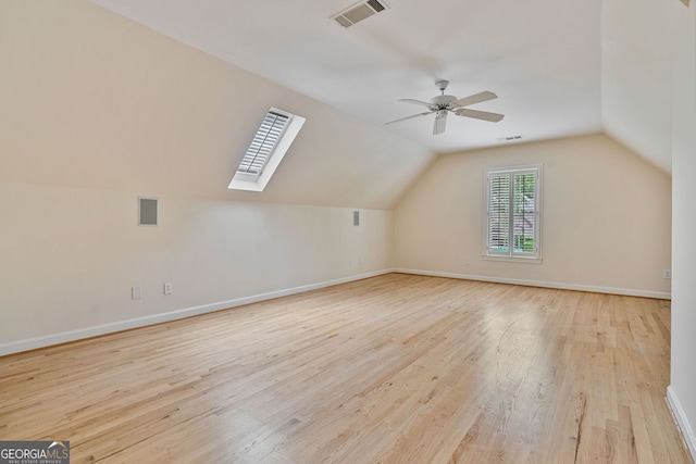bonus room featuring a skylight, wood finished floors, plenty of natural light, vaulted ceiling, and ceiling fan