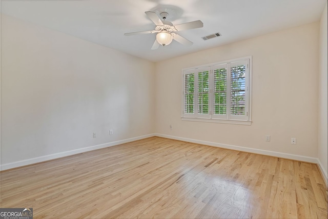 empty room featuring baseboards, wood finished floors, and a ceiling fan