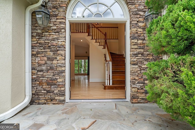 entrance to property featuring stone siding and stucco siding