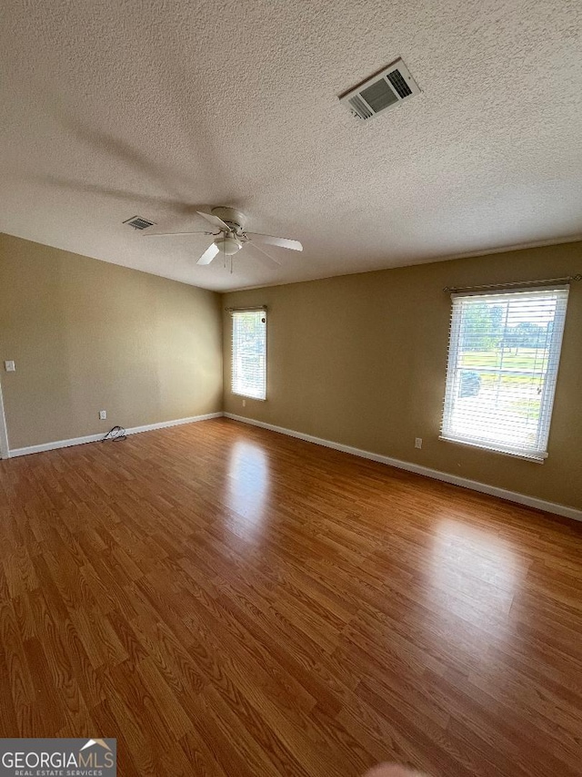 1640 Hg Miles Dr NE, Townsend, GA 31331 - spare room with a ceiling fan, wood finished floors, a textured ceiling, baseboards, and visible vents