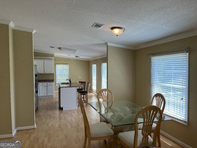 1640 Hg Miles Dr NE, Townsend, GA 31331 - dining space featuring a textured ceiling, light wood-type flooring, baseboards, visible vents, and crown molding
