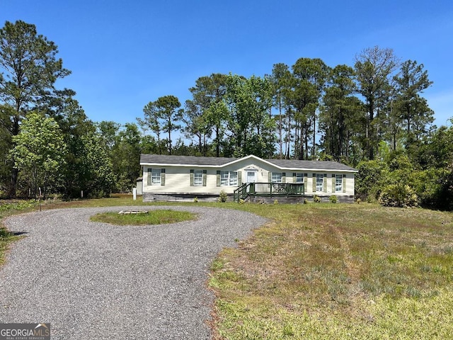 1640 Hg Miles Dr NE, Townsend, GA 31331 - view of front facade featuring a wooden deck, gravel driveway, and crawl space