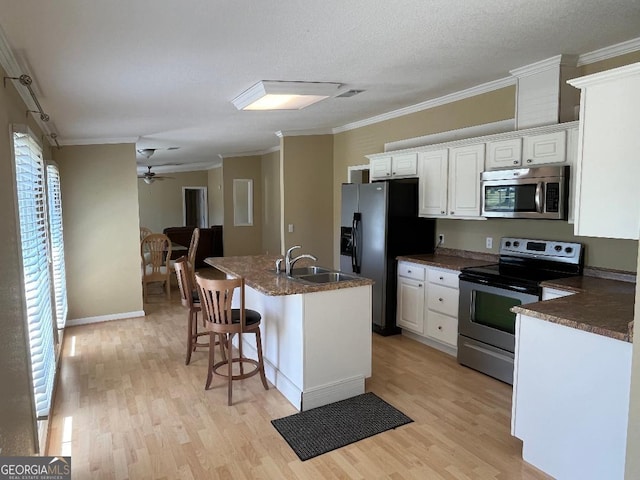 1640 Hg Miles Dr NE, Townsend, GA 31331 - kitchen featuring stainless steel appliances, light wood-style flooring, a sink, dark countertops, and ornamental molding