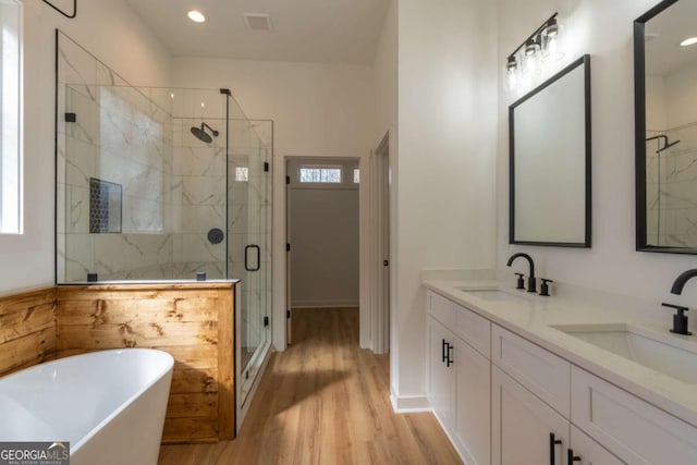 1250 Hayes Mill Rd, Carrollton, GA 30117 - full bath featuring a marble finish shower, a freestanding bath, wood finished floors, double vanity, and recessed lighting
