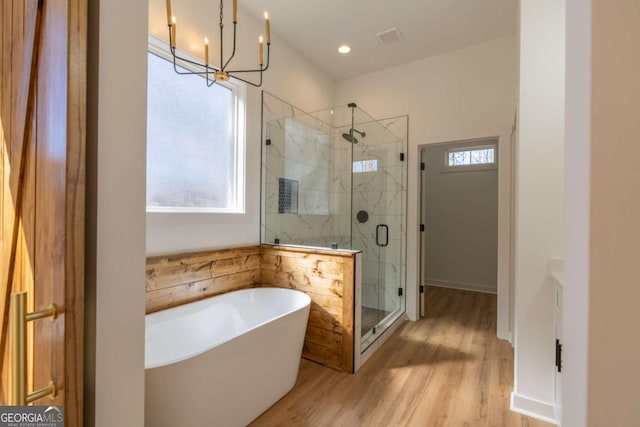 1250 Hayes Mill Rd, Carrollton, GA 30117 - bathroom with a freestanding tub, a chandelier, wood finished floors, and a marble finish shower