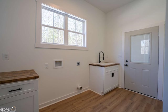 1250 Hayes Mill Rd, Carrollton, GA 30117 - laundry area with hookup for an electric dryer, hookup for a washing machine, light wood-style flooring, and cabinet space