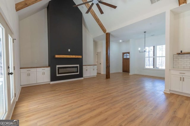 1250 Hayes Mill Rd, Carrollton, GA 30117 - unfurnished living room with high vaulted ceiling, ceiling fan, light wood-style flooring, a chandelier, and beamed ceiling