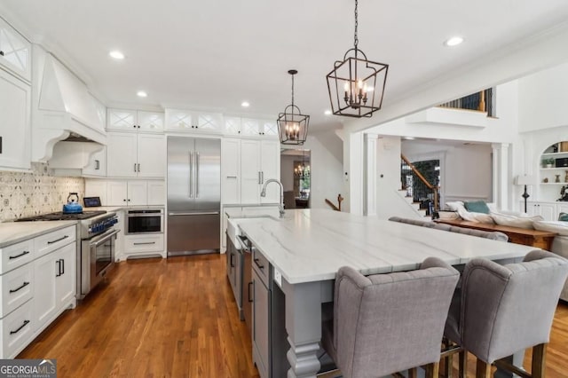 3115 Corsair Curv, Cumming, GA 30040 - kitchen featuring high end appliances, open floor plan, a chandelier, white cabinetry, and recessed lighting