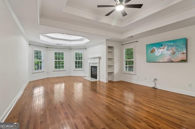 3115 Corsair Curv, Cumming, GA 30040 - unfurnished living room featuring a raised ceiling, wood-type flooring, ceiling fan, a premium fireplace, and ornamental molding