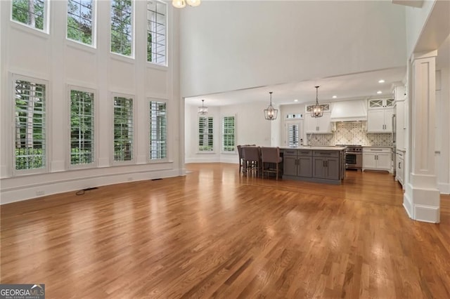 3115 Corsair Curv, Cumming, GA 30040 - living room featuring a chandelier, a towering ceiling, wood finished floors, and recessed lighting
