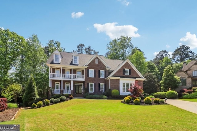 3115 Corsair Curv, Cumming, GA 30040 - view of front of property with a balcony, a front yard, brick siding, and covered porch